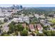 Aerial view of a residential area featuring apartments, townhouses, and lush green trees with the city skyline in the distance at 220 Renaissance Ne Pkwy # 1105, Atlanta, GA 30308