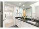 Well-lit bathroom featuring dual sinks with granite counters and an adjacent bedroom at 220 Renaissance Ne Pkwy # 1105, Atlanta, GA 30308