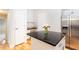 Bright kitchen features an island with a black countertop, stainless steel refrigerator, and white cabinets at 220 Renaissance Ne Pkwy # 1105, Atlanta, GA 30308