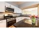 Modern kitchen with stainless steel appliances, granite countertops, and white cabinetry at 220 Renaissance Ne Pkwy # 1105, Atlanta, GA 30308