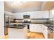 Well-lit kitchen boasts stainless steel appliances, island, and sleek white cabinets at 220 Renaissance Ne Pkwy # 1105, Atlanta, GA 30308