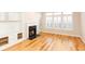Bright living room with hardwood floors, fireplace, built-in shelving, and large windows with shutters at 220 Renaissance Ne Pkwy # 1105, Atlanta, GA 30308
