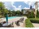A relaxing pool area is surrounded by lounge chairs, tables, and lush landscaping at 220 Renaissance Ne Pkwy # 1105, Atlanta, GA 30308