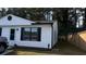 A house featuring white siding and black window trim, complemented by a well-kept lawn and a wooden fence at 4778 Pebble Trce, Buford, GA 30518