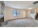 Cozy living room featuring carpeted floors, a stone fireplace, and large windows for natural light at 11111 Shannon Cir, Hampton, GA 30228