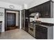 This kitchen features black cabinets, stainless steel appliances, granite counters and tile floors at 3638 Peachtree Rd # 306, Atlanta, GA 30319
