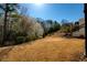 Spacious backyard featuring a sloped landscape and lush trees that create a serene and private outdoor space at 1760 Grand Oaks Drive, Woodstock, GA 30188