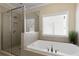 Bathroom featuring soaking tub, a glass shower and a view from the window at 1760 Grand Oaks Drive, Woodstock, GA 30188