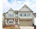 Charming two-story home with stone accents, a welcoming porch, and a two-car garage at 1760 Grand Oaks Drive, Woodstock, GA 30188