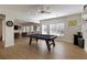 Open-concept game room featuring a pool table, natural light, and a seamless connection to the living area at 1760 Grand Oaks Drive, Woodstock, GA 30188