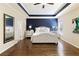 Spacious main bedroom with a tray ceiling, hardwood floors, and a decorative accent wall at 1760 Grand Oaks Drive, Woodstock, GA 30188