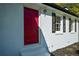 Close-up of a painted white brick home featuring a bright red front door and black shutters at 2157 Tiffany Ln, Lithonia, GA 30058