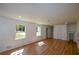 Large open room with wood floors, natural light, and a staircase at 2157 Tiffany Ln, Lithonia, GA 30058