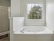 Bright bathroom features a soaking tub with jets and a window with a treed view at 2205 Dresden Nw Grn, Kennesaw, GA 30144