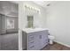 Bathroom with modern vanity, mirror with decorative lighting, and view to bedroom space at 2205 Dresden Nw Grn, Kennesaw, GA 30144