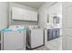 Laundry room with white washer and dryer, overhead cabinet storage and access to kitchen at 2205 Dresden Nw Grn, Kennesaw, GA 30144