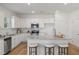 Bright kitchen featuring white cabinets, granite countertops, stainless steel appliances, and a cozy island with bar stool seating at 465 Madison Lakeview Dr, Acworth, GA 30102