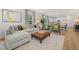 Open-concept living room with a large sectional couch, plush rug, and plenty of natural light at 465 Madison Lakeview Dr, Acworth, GA 30102