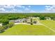 Panoramic aerial view of a horse farm highlighting vast grounds and multiple buildings and wooded expanses at 8599 Secretariat Dr, Lithonia, GA 30058