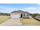 Inviting single-story home showcasing a two-car garage, neutral siding, and landscaped front yard at 8599 Secretariat Dr, Lithonia, GA 30058