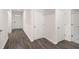 Hallway featuring wood-look flooring, white walls, and white doors leading to various rooms at 8599 Secretariat Dr, Lithonia, GA 30058