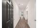 Long hallway with wood-look floors, white walls, and recessed lighting leads to a bright room at 8599 Secretariat Dr, Lithonia, GA 30058