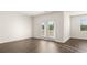 Living room with wood floors, windows, and glass doors to the backyard at 8599 Secretariat Dr, Lithonia, GA 30058