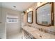 Bathroom featuring double sinks with a marble countertop, gold hardware, and neutral tones at 440 River Valley Rd, Atlanta, GA 30328
