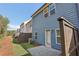 Back exterior displaying a compact patio and fenced yard, complemented by the blue siding and surrounding greenery at 1115 Lockhart Way, Douglasville, GA 30135