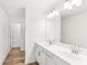 Well-lit bathroom showcases double sinks with white cabinets and modern fixtures beneath a large mirror at 1115 Lockhart Way, Douglasville, GA 30135