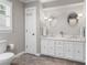 Bathroom features a double vanity, white cabinets, wood floors, and modern fixtures at 1380 Tennis Court Pl, Roswell, GA 30075