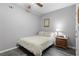 Neutral bedroom with a ceiling fan, a comfortable bed, and a nightstand with a lamp at 1380 Tennis Court Pl, Roswell, GA 30075