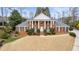 Inviting two-story brick home featuring classic architecture, lush lawn, and mature trees at 1380 Tennis Court Pl, Roswell, GA 30075