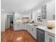 Updated kitchen featuring white cabinets, stainless steel appliances, and hardwood floors at 1380 Tennis Court Pl, Roswell, GA 30075