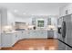 Modern kitchen with white cabinets, stainless steel appliances, and hardwood floors for a sleek look at 1380 Tennis Court Pl, Roswell, GA 30075