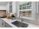 Close up of the kitchen sink with quartz counters and a window view of the waterfall feature outside at 1380 Tennis Court Pl, Roswell, GA 30075