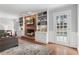 Bright living room featuring brick fireplace, built-in shelving, and hardwood flooring at 1380 Tennis Court Pl, Roswell, GA 30075
