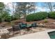 Outdoor seating area with comfortable chairs, a stone retaining wall, and lush greenery at 1380 Tennis Court Pl, Roswell, GA 30075