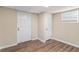 Finished basement space with wood-look flooring, neutral walls and white doors at 3552 Meadowview Dr, Lithia Springs, GA 30122