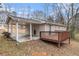 Back exterior view with deck, gravel and covered parking with outside lighting at 3552 Meadowview Dr, Lithia Springs, GA 30122