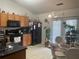 Well-lit eat-in kitchen featuring black appliances, hanging pendant lights, and vinyl flooring at 4644 Pine Isle Way, Sugar Hill, GA 30518