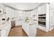 Well-appointed kitchen with white cabinetry, granite countertops, an island, and stainless appliances at 5945 Masters Club Dr, Suwanee, GA 30024