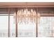 Stunning crystal chandelier hanging in front of large windows with a city view at 1065 Peachtree Ne St # 3105, Atlanta, GA 30309