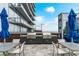 Outdoor grilling area with two stainless steel grills, lounge chairs, and blue umbrellas at 1065 Peachtree Ne St # 3105, Atlanta, GA 30309