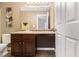 Bathroom vanity featuring dark wood cabinets, a sink with chrome fixtures, and decorative wall art at 2258 Bigwood Trail Trl, Atlanta, GA 30349