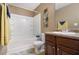 Bathroom with a white tub/shower combination, dark wood cabinets, and decorative wall art at 2258 Bigwood Trail Trl, Atlanta, GA 30349