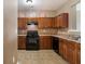 Traditional kitchen featuring brown cabinets, black appliances, and neutral countertops at 2258 Bigwood Trail Trl, Atlanta, GA 30349