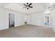 Bright main bedroom featuring tray ceilings, a ceiling fan, and access to an ensuite bathroom at 8026 Rivermont Ct, Snellville, GA 30039