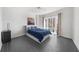 A bright bedroom with a large window, gray floors, and a comfortable bed with stylish blue accents at 3475 Oak Valley Ne Rd # 410, Atlanta, GA 30326