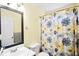 Cozy bathroom featuring a floral shower curtain, white toilet and sink, and a framed mirror on a yellow wall at 4046 Harvest Ridge Dr, Douglasville, GA 30135